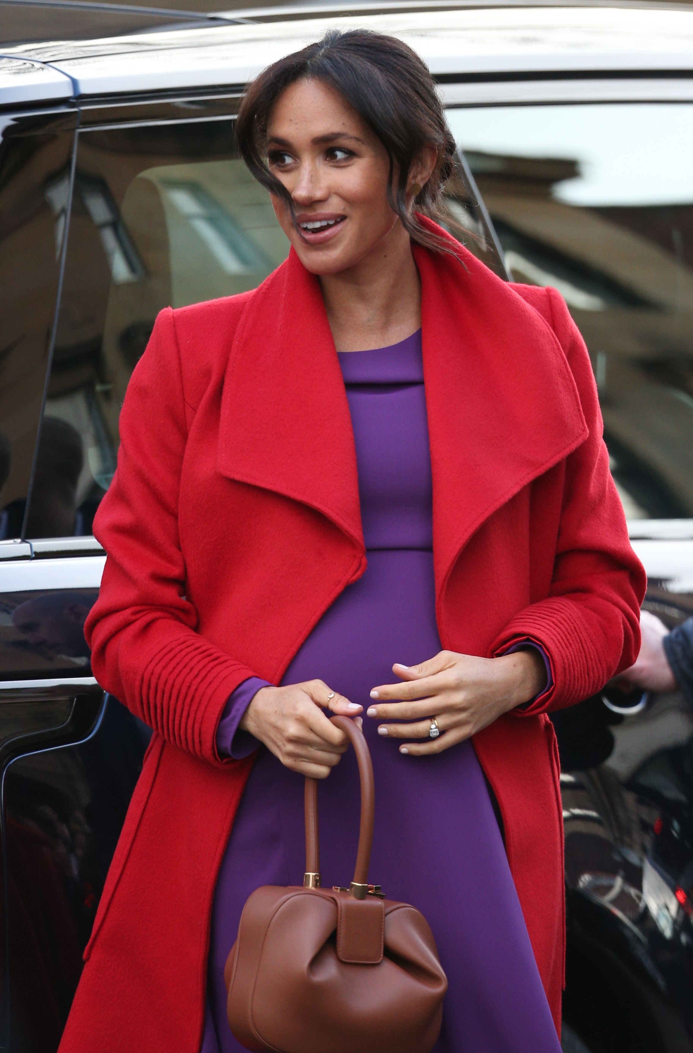 Meghan Markle Pairs A Bright Red Coat With A Purple Dress In Birkenhead