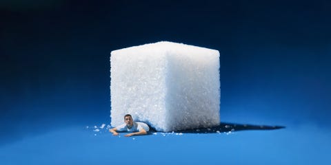 a large sugar cube with a person emerging from underneath it