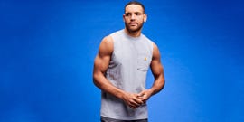 Model showcasing a sleeveless gray shirt against a blue background