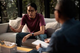 male therapist listening to a man talk on a private therapy session.
