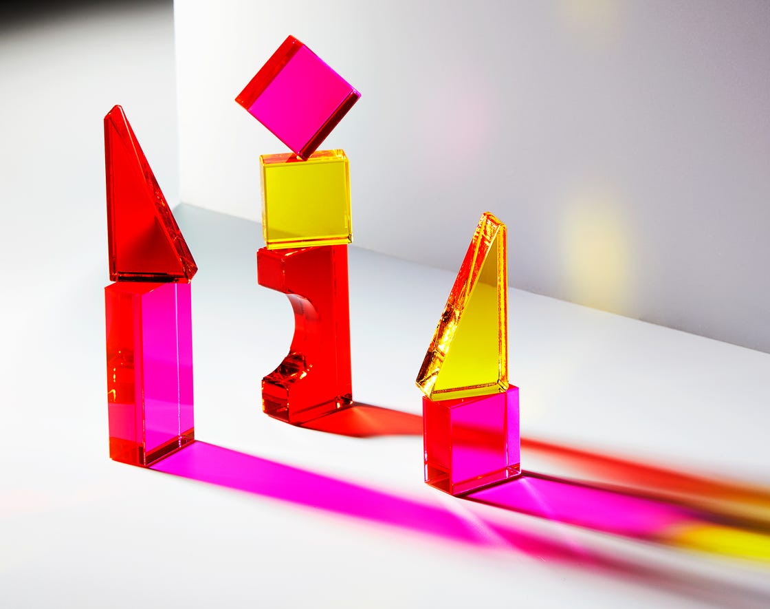 Colorful geometric shapes made of transparent material casting shadows