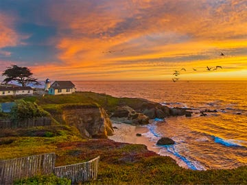 Pelicans soar past the lighthouse at Point Montara, north of Half Moon Bay.