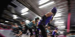 Members of the Varsity Brawlers team (purple tops) compete against the Tough Cookies team during a L.A. Derby Dolls women's banked track roller derby event in Los Angeles.