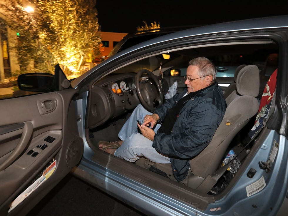 John Frawley checks his email before closing up his car and going to sleep.