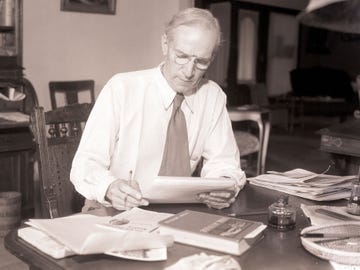 Upton Sinclair, militant international author and Socialist, who captured the Democratic nomination for Governor of California, reads a paper at a desk in 1934.