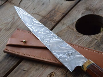 A Wilburn Forge culinary knife with a 10-inch integral blade (2 1/8 inches wide at the heel) with a handle of stabilized amboyna.