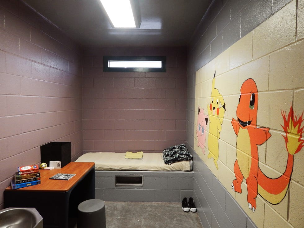A youth’s room at the detention center, with a mural painted by nearby college students.
