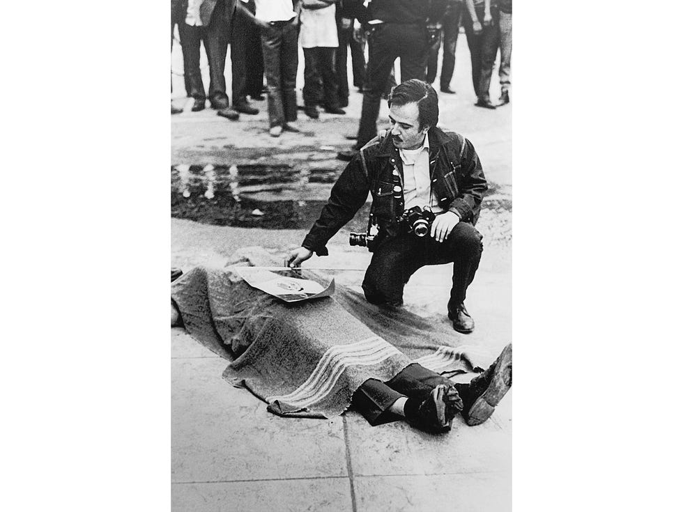 Raul Ruiz lays a Mexican flag atop the corpse of Gustav Montag, a bystander slain by ricochet ammunition during a 1971 protest in East Los Angeles.