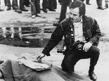 Raul Ruiz lays a Mexican flag atop the corpse of Gustav Montag, a bystander slain by ricochet ammunition during a 1971 protest in East Los Angeles.