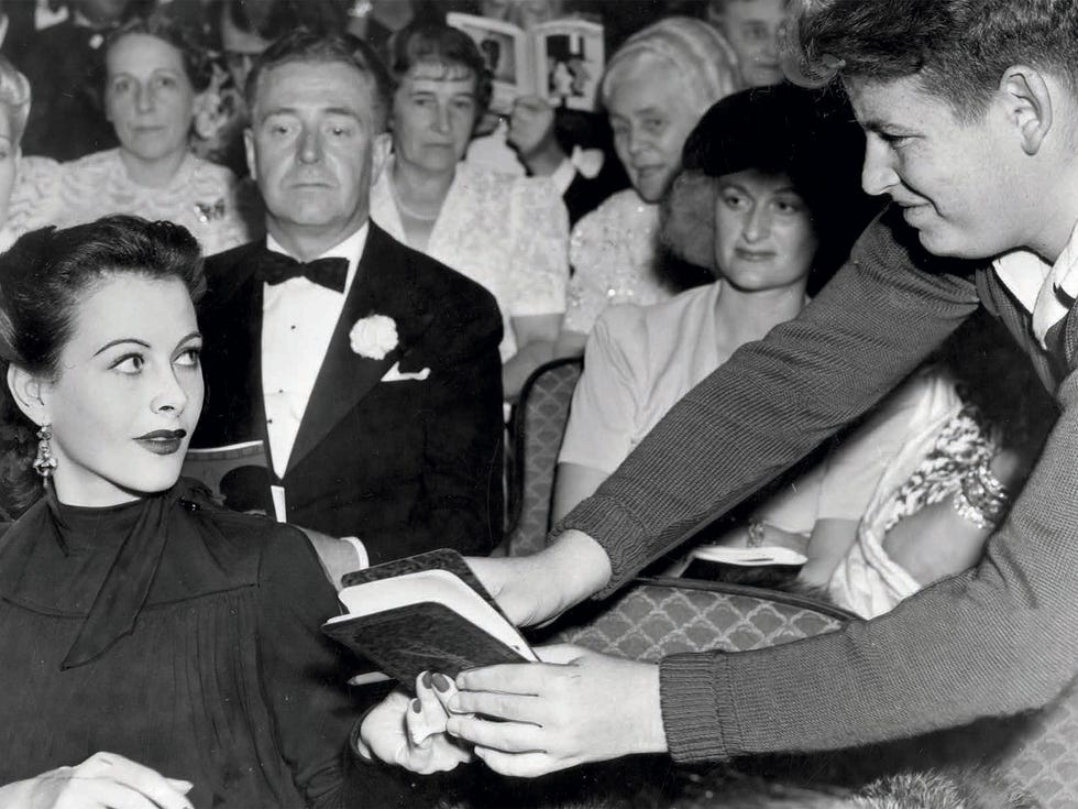 Hedy Lamarr signs an autograph book at the El Capitan Theatre in Hollywood, 1940. Photo from The Autograph Book of L.A.: Improvements on the Page of the City.