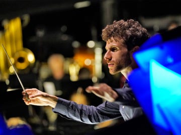 la opera’s first artist in residence, composer conductor and macarthur fellow matthew aucoin, leads the company’s orchestra in a 2018 production of rigoletto