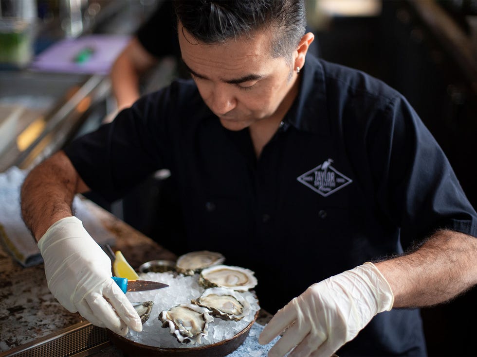 Louis Morales, general manager at Taylor Shellfish in Pioneer Square, prepares a Shucker’s Dozen plate.