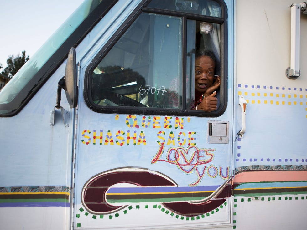 Overnight visitor Shasha “Queen” Sage greets people from the door of her RV.