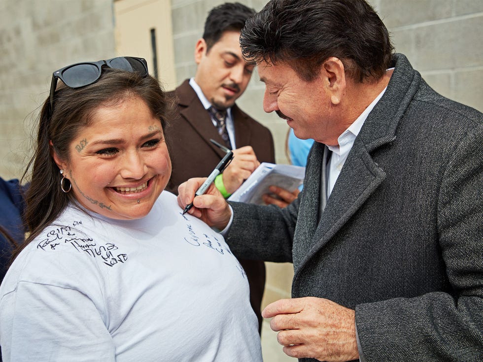 Band members Óscar Lara (right) and Luis Hernández (center) sign autographs for incarcerated fans.