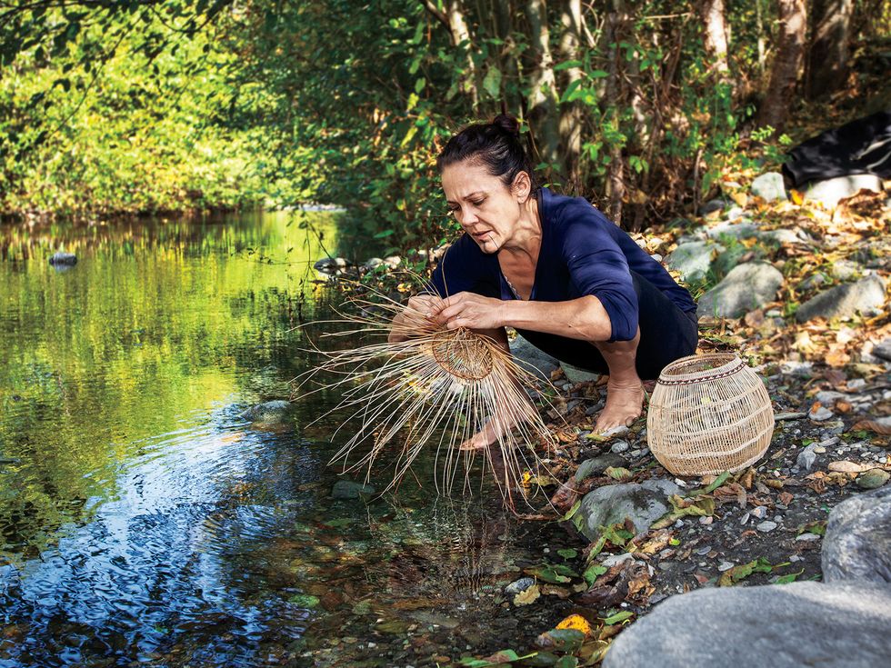 Lisa Hillman, a Pikyav Field Institute program manager, weaves plant materials that she dunks in water to make them more pliable. After a burn, the new shoots of hazel shrubs are sought by basket makers.