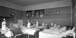 Nurses wearing breathing masks administer to patients in the ward, believed to be the isolation ward at Pasadena's Wilson High School during the 1919 influenza epidemic.