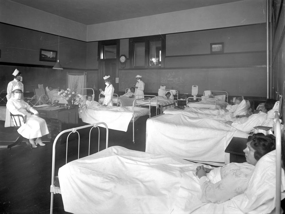 Nurses wearing breathing masks administer to patients in the ward, believed to be the isolation ward at Pasadena's Wilson High School during the 1919 influenza epidemic.
