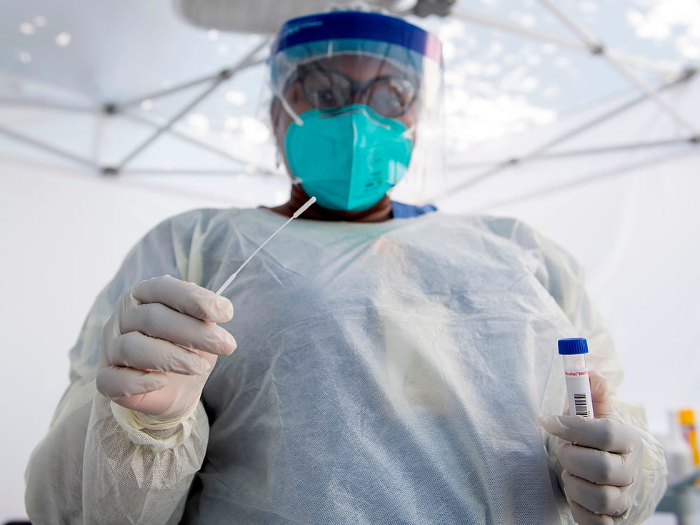 A health worker takes a nasal swab sample at a COVID-19 testing site in Los Angeles, amid the novel coronavirus pandemic.