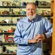 Kevin Kelly in front of his Curiosity Wall at his studio in Pacifica. The narrow shelves hold some of the items he’s amassed during a lifetime of travel near and far.