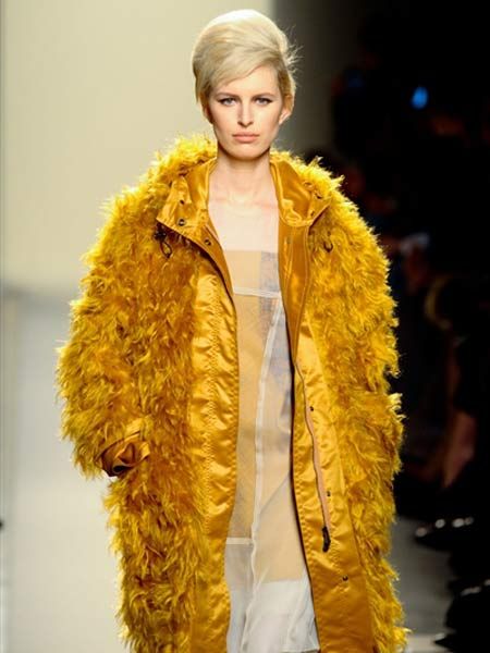 Yellow, Fashion show, Textile, Fur clothing, Outerwear, Jacket, Style, Fashion model, Natural material, Animal product, 
