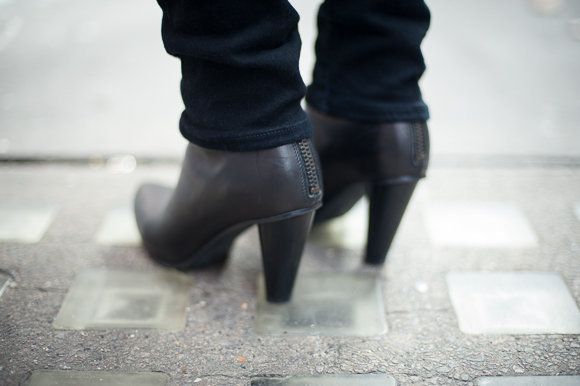 Human leg, Black, Grey, Leather, Boot, Street fashion, Foot, Cobblestone, Ankle, Synthetic rubber, 
