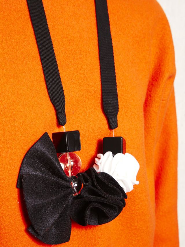 Sleeve, Orange, Costume accessory, Glove, Medal, Active shirt, Strap, Safety glove, 