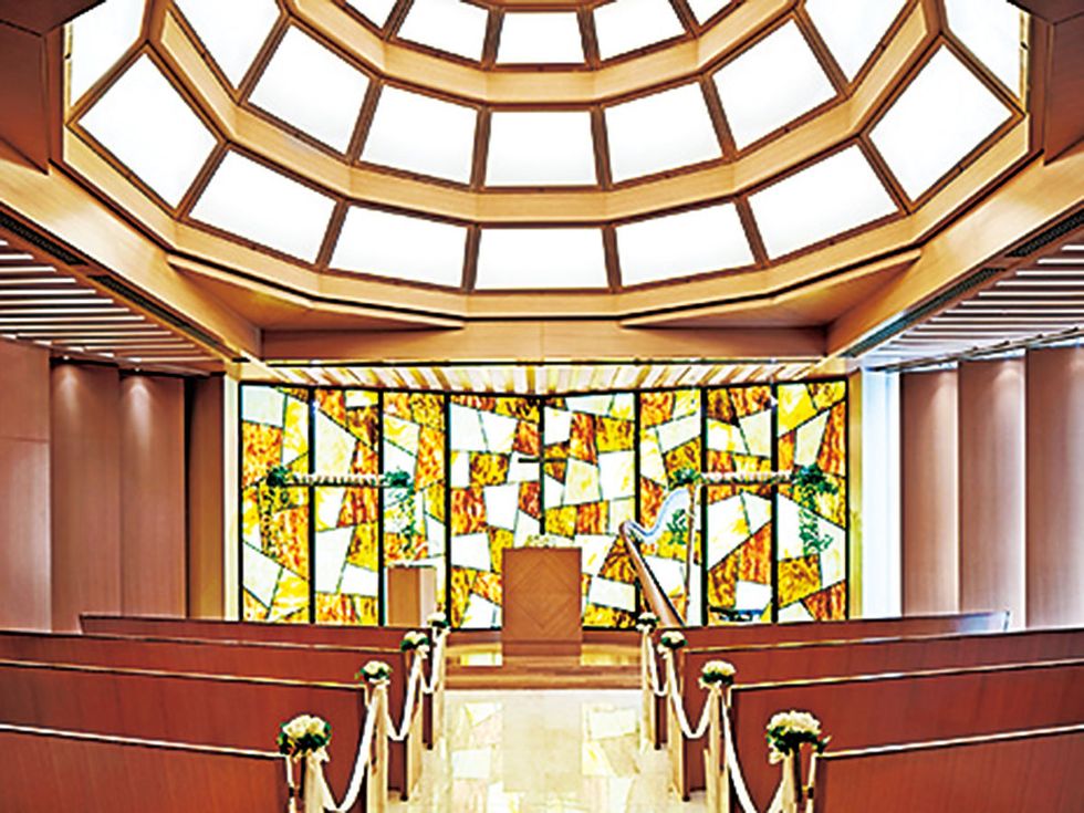 Yellow, Interior design, Ceiling, Glass, Amber, Fixture, Place of worship, Bench, Symmetry, Chapel, 