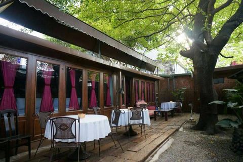 Tree, Tablecloth, Furniture, Linens, Shade, Restaurant, Outdoor table, Houseplant, Courtyard, Outdoor furniture, 