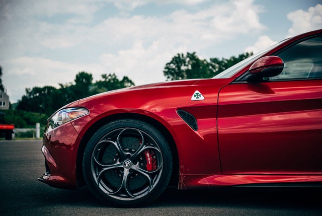 front end of alfa romeo giulia with woods in the background