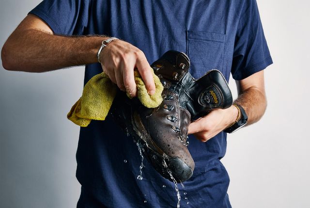 a person washing a leather hiking boot
