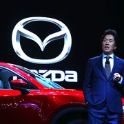 Mazda North American Operations CEO Masahiro Moro speaking in front of a Mazda CX-5.
