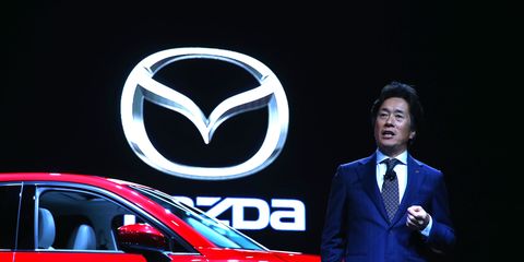 Mazda North American Operations CEO Masahiro Moro speaking in front of a Mazda CX-5.
