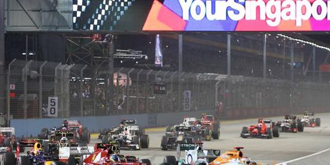 2012 Singapore Grand Prix: Paul di Resta, Force India VJM05 Mercedes, leads Fernando Alonso, Ferrari F2012, Mark Webber, Red Bull RB8 Renault, and the remainder of the field through the first corner.