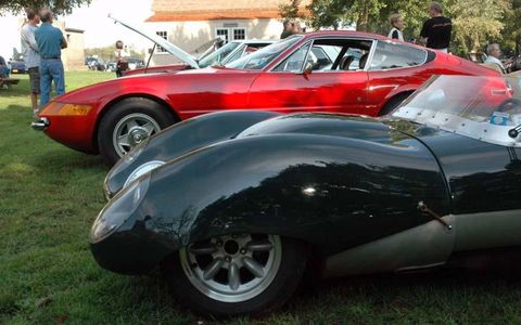 A 1957 Lotus 11 and a Ferrari Daytona sit side by side.