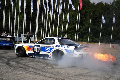 Fire spews from a Mazda RX7 driven by New Zealand drifter Mike Whiddett.