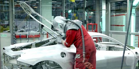 A worker fine tunes the fit of the rear hatch on a 458 Italia.