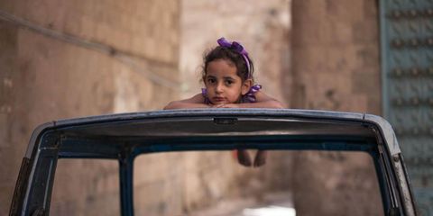 Looking forward  // Yemen continues to face economic hardship and political uncertainty following the February departure of president A. Abdullah Saleh. Here, a young girl rests on the roof of an abandoned car in Sana'a, Yemen's old city.