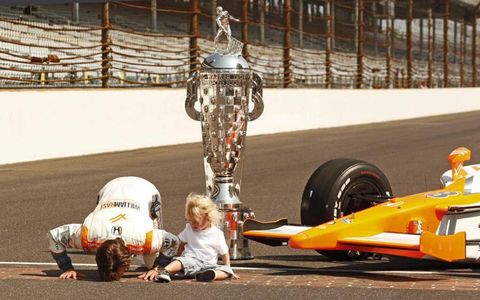 Dan Wheldon kisses the yard of bricks in May 2011, one day after winning his second Indianapolis 500. With him is his son, Sebastian.