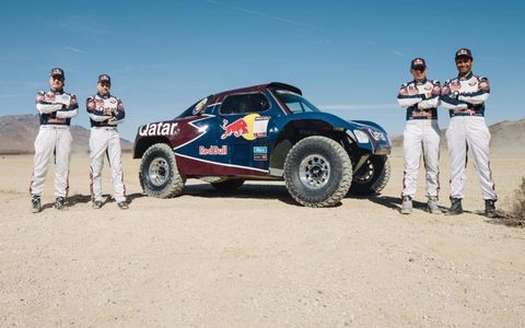 STANDING TALL // Members of the Qatar Red Bull Rally Team pose next to their off-road buggy on Nov. 11. The team is practicing in California&#8217;s Apple Valley ahead of the 2013 Dakar Rally. Photo by Tony Harmer/Red Bull