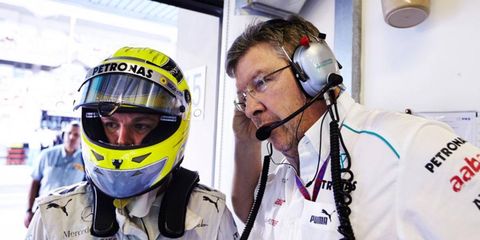 Ross Brawn, right, says he still plans to run the racing operation for Mercedes this season.