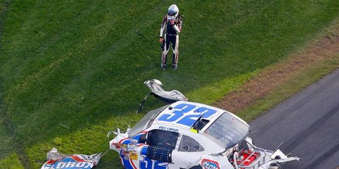 NASCAR Nationwide Series driver Kyle Larson looks over the remains of his car after a dramatic crash on Saturday at Daytona International Speedway.