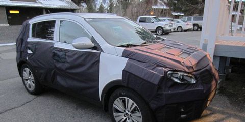 Despite the camouflage, the roofline and pillars give this away as a Kia Sportage crossover.