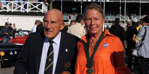Sir Stirling Moss, holding hands with a woman, presumably, without the aptitude to win a Formula One race...