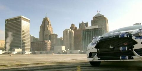 With the Detroit skyline as a backdrop, a Ford Fiesta ST Rallycross car gets a workout on the top deck of a parking structure.