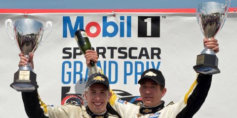 Tommy Milner, left, celebrates on the podium with Corvette Racing teammate Oliver Gavin after winning at Canadian Tire Motorsports Park.
