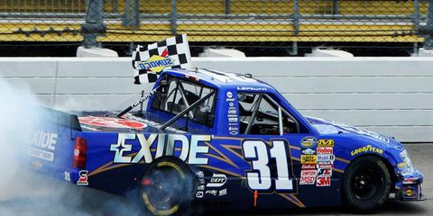 James Buescher survived a second green-white-checkered finish to win the NASCAR Camping World Truck Series race at Iowa on Sunday.