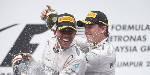Lewis Hamilton gets a champagne shower from Mercedes teammate Nico Rosberg after Hamilton won the Malaysian Grand Prix.