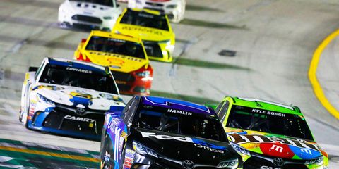Denny Hamlin, left, and eventual race winner Kyle Busch battle at Kentucky Speedway on Saturday night in NASCAR's first race with a new aero package designed to produce more passing.