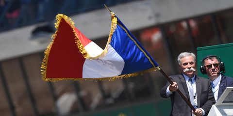 Formula 1 CEO Chase Carey waves the French flag to signify the start of the 24 Hours of Le Mans.