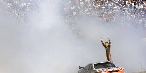 Kyle Busch celebrates his NASCAR Sprint Cup win on the track at Atlanta.